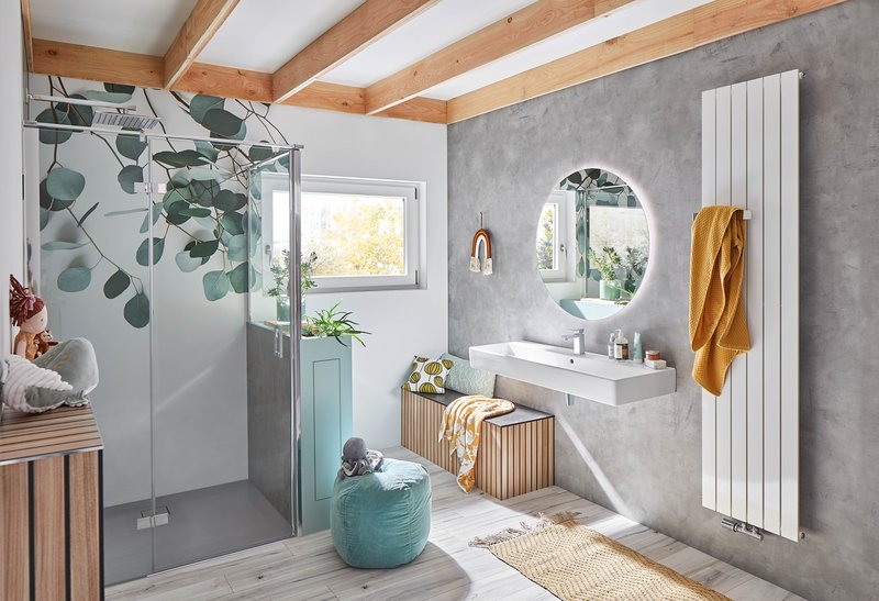Dieses Badezimmer kombiniert moderne Elemente mit natürlichen Materialien. Die Dusche wird durch eine Eukalyptus-Blättertapete optisch aufgewertet, während Holzdetails und ein Sichtbeton-Look eine warme und stilvolle Atmosphäre schaffen.