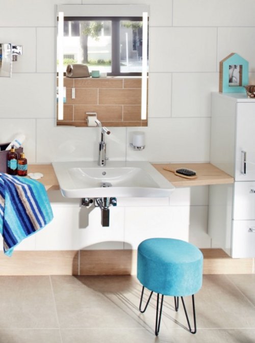 Stilvolles, barrierefreies Badezimmer mit unterfahrbarem Waschbecken, modernem Spiegel mit Beleuchtung und funktionalen Ablageflächen für maximalen Komfort.
